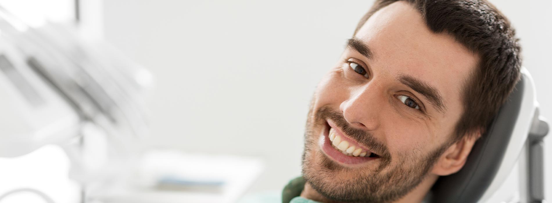 A well-lit reception area with a desk, computer monitor, and potted plant.